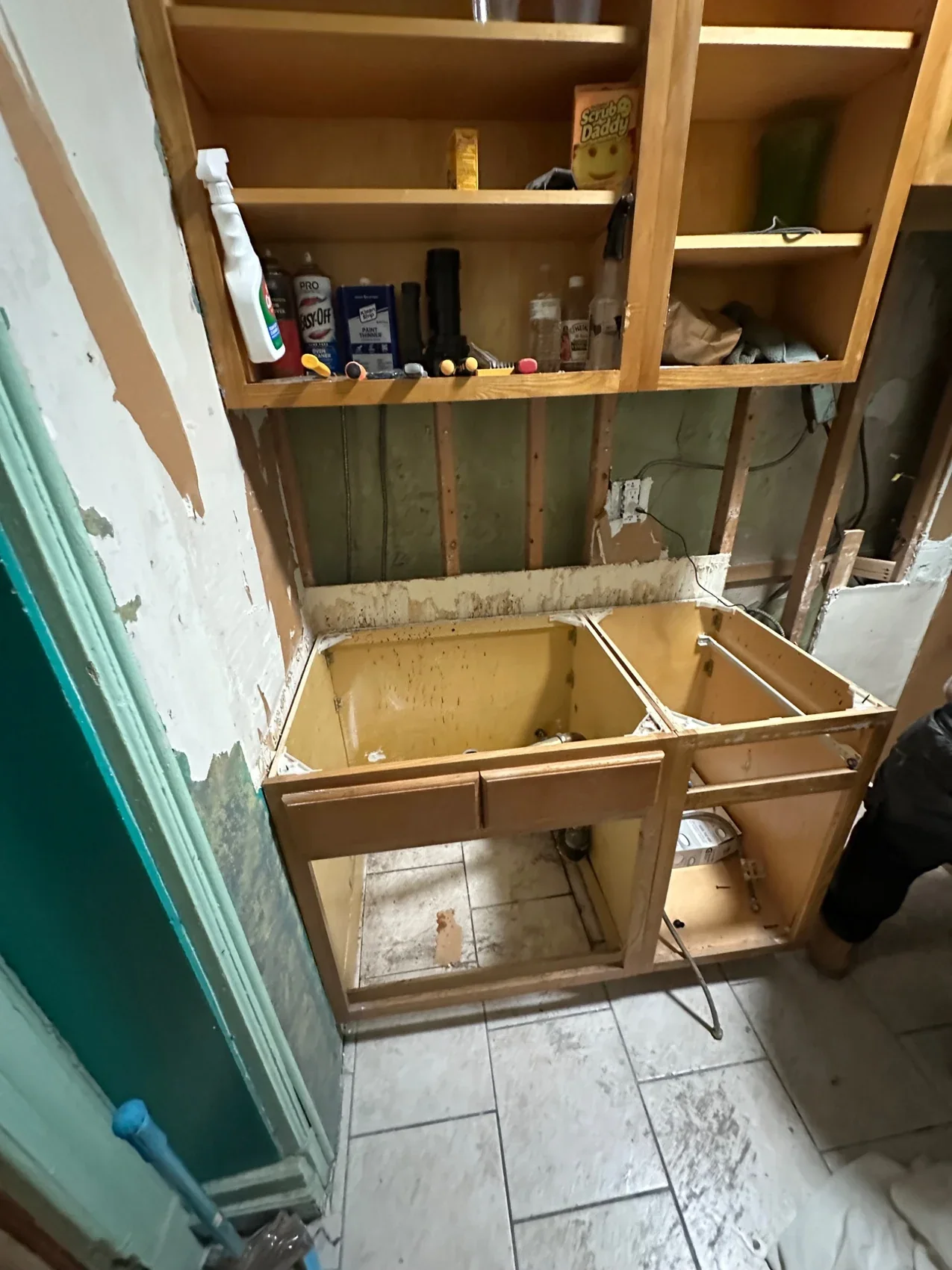 Kitchen before renovation with exposed wall framing and sink base cabinets under construction